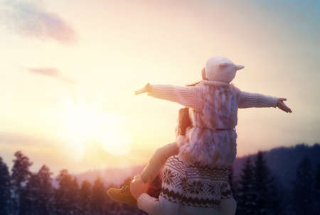 Happy loving family! Father and his daughter are playing and hugging outdoors. Cute little girl and daddy on snowy winter walk in nature. Concept of frost winter season.の写真素材