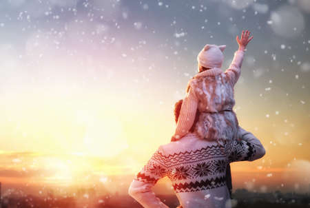 Happy loving family! Father and his daughter are playing and hugging outdoors. Cute little girl and daddy on snowy winter walk in nature. Concept of frost winter season.の写真素材