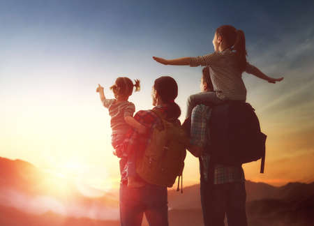 Happy family at sunset. Father, mother and two children daughters having fun and enjoying journey....
