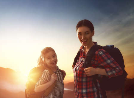 Two travelers at sunset. Mother and child daughter girl are having fun and enjoying journey.の写真素材