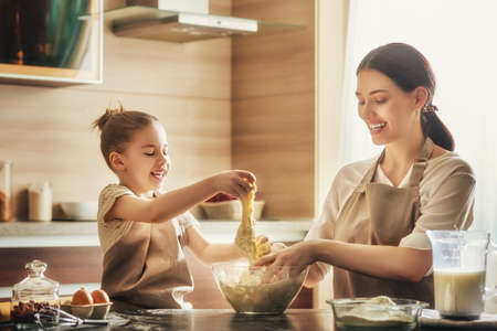Happy loving family are preparing bakery together. Mother and child daughter girl are cooking...