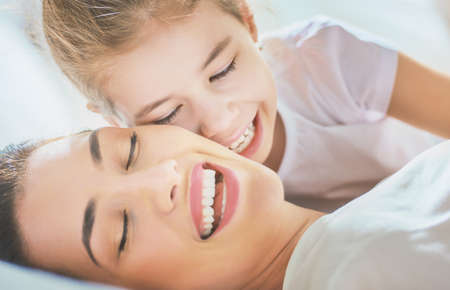 Happy mother's day! Mom and her daughter child girl are playing, smiling and hugging. Family holiday and togetherness.の写真素材