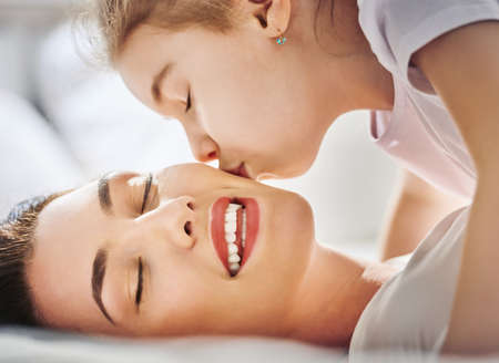 Happy mother's day! Mom and her daughter child girl are playing, smiling and hugging. Family holiday and togetherness.の写真素材