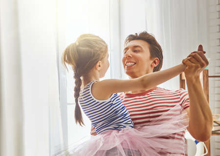 Happy father's day! Dad and his daughter child girl are playing, smiling and dancing. Family holiday and togetherness.の写真素材