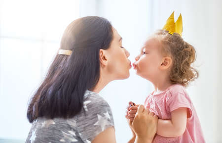 Happy loving family. Mother and her daughter child baby girl playing, hugging and kissing.の写真素材
