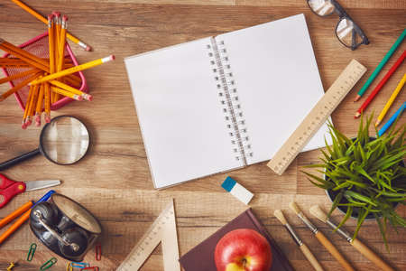 Back to school and happy time! Wooden desk with supplies. Top view.
