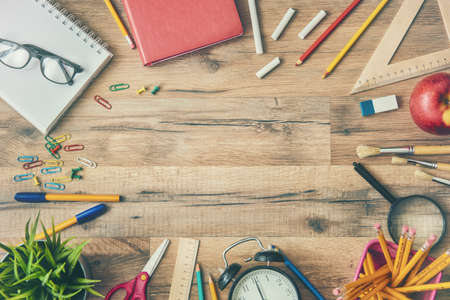 Back to school and happy time! Wooden desk with supplies. Top view.