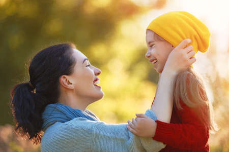 Happy family on autumn walk! Mother and daughter walking in the Park and enjoying the beautiful autumn nature.の写真素材