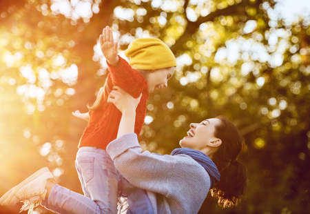 Happy family on autumn walk! Mother and daughter walking in the Park and enjoying the beautiful autumn nature.の写真素材