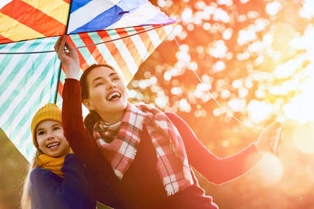 Happy family on autumn walk! Mother and daughter walking in the Park and enjoying the beautiful autumn nature.の写真素材