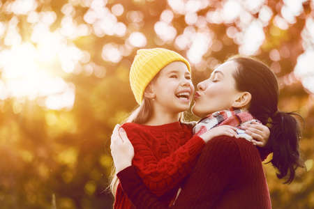 Happy family on autumn walk! Mother and daughter walking in the Park and enjoying the beautiful autumn nature.の写真素材