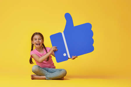 Cute little child girl with cartoon like icon on colorful background. Yellow, pink and blue colors.の写真素材