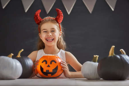 Cute little child with pumpkin. Happy family preparing for Halloween.の写真素材