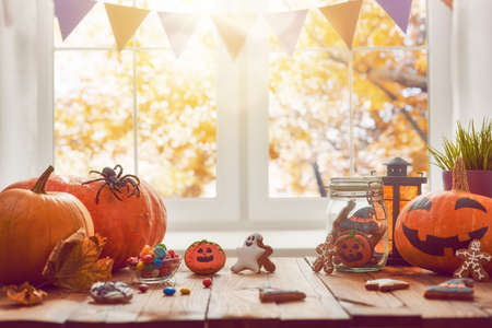 Happy Halloween! Pumpkin, sweets and cookies on the table in the home. Preparation for holiday.の写真素材