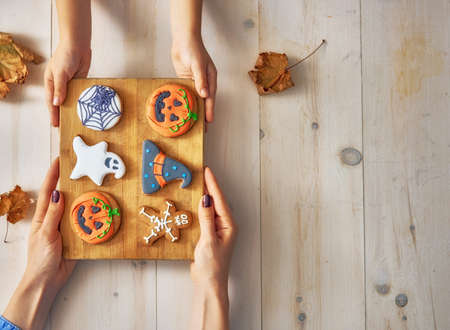 Happy halloween! A mother and daughter having festive sweets on the table in the home. Family preparing for holiday. Top view. Close up.の写真素材