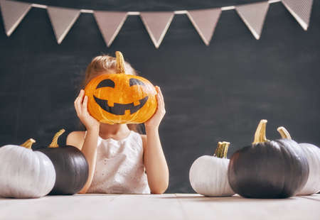 Cute little child with pumpkin. Happy family preparing for Halloween.の写真素材