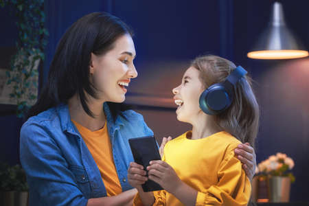 Happy loving family. Young mother and her daughter girl are playing in bedroom. Funny mom and lovely...