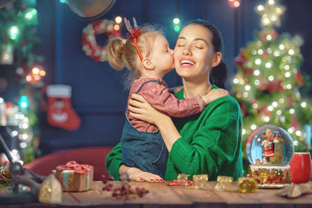 Merry Christmas and Happy Holiday! Mom and daughter near the tree at home.の写真素材