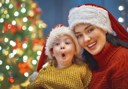 Merry Christmas and Happy Holiday! Mom and daughter near the tree at home.の写真素材