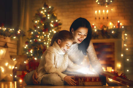 Merry Christmas and Happy Holiday! Loving family mother and child with magic gift box.の写真素材