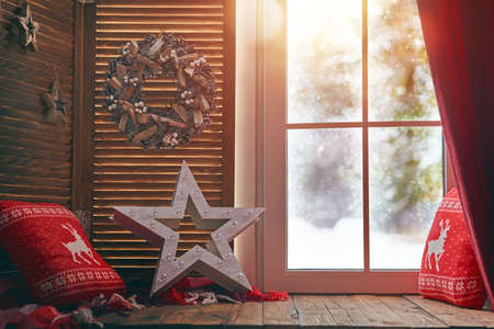 Merry Christmas! Room decorated for holidays. Winter forest from the window of the house.の写真素材