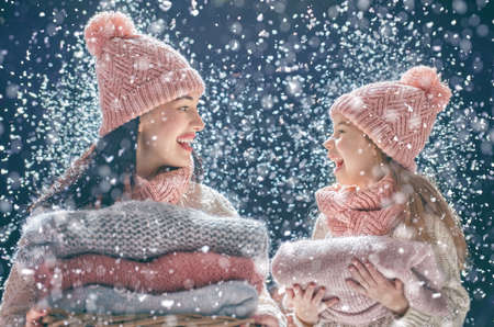 Happy loving family! Mother and child girl having fun, playing and laughing on snowy winter walk in nature. Frost winter season. の写真素材