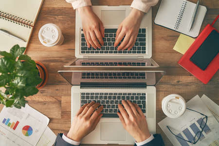 man and woman working on their computers. the view from the top.の写真素材