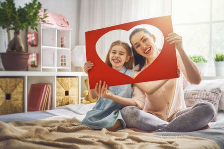 Happy mother's day! Mom and her daughter child girl are playing, smiling and hugging. Family holiday and togetherness.の写真素材