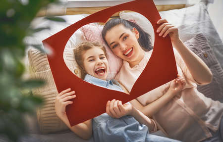Happy mother's day! Mom and her daughter child girl are playing, smiling and hugging. Family holiday and togetherness.の写真素材