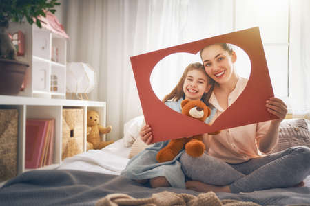Happy mother's day! Mom and her daughter child girl are playing, smiling and hugging. Family holiday and togetherness.の写真素材