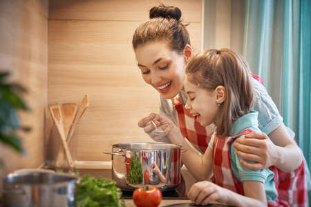Healthy food at home. Happy family in the kitchen. Mother and child daughter are preparing on the...