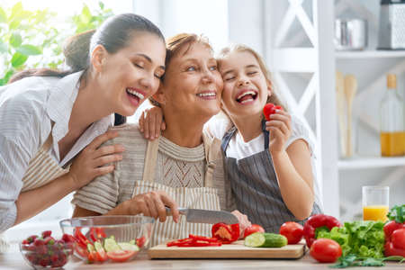 Healthy food at home. Happy family in the kitchen. Grandma, mother and child daughter are preparing...
