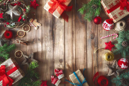 Merry Christmas and Happy Holidays! Baubles with ornaments and gift boxes on wooden desk. Top view....