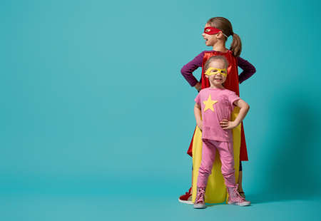 Little children are playing superhero. Kids on the background of bright wall. Girl power concept.の写真素材