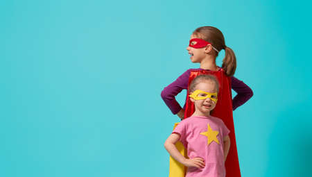 Little children are playing superhero. Kids on the background of bright wall. Girl power concept.の写真素材