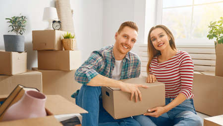 Happy young married couple are moving to new apartment.