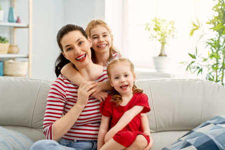 Happy mother's day! Mom and her daughters children girls are playing, smiling and hugging. Family...