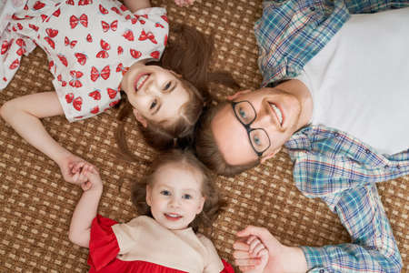 Happy loving family. Daddy and his daughters children girls playing together. Father's day concept.の写真素材