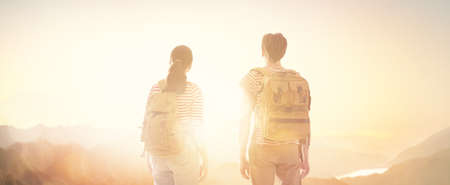 Toward adventure! Man and woman enjoying journey. Couple looks at sunset.の写真素材