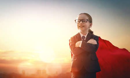 superhero businessman child on sunset background. the concept of success, leadership and victory in...