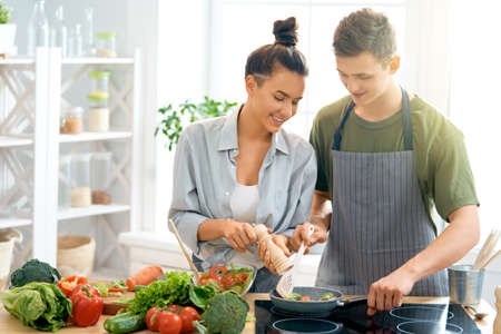 Healthy food at home. Happy loving couple is preparing the proper meal in the kitchen.の写真素材