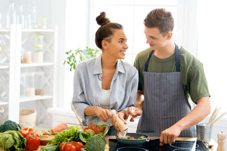 Healthy food at home. Happy loving couple is preparing the proper meal in the kitchen.
