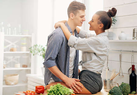 Healthy food at home. Happy loving couple is preparing the proper meal in the kitchen.の写真素材