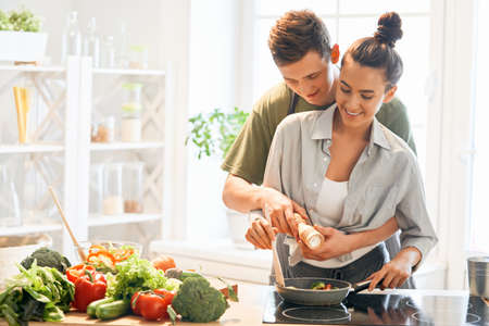 Healthy food at home. Happy loving couple is preparing the proper meal in the kitchen.の写真素材