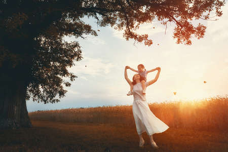 Happy family on autumn walk! Mother and daughter walking in the Park and enjoying the beautiful autumn nature.の写真素材