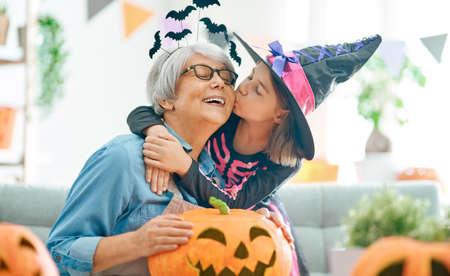 Happy family celebrating Halloween. Grandmother and child at home.の写真素材