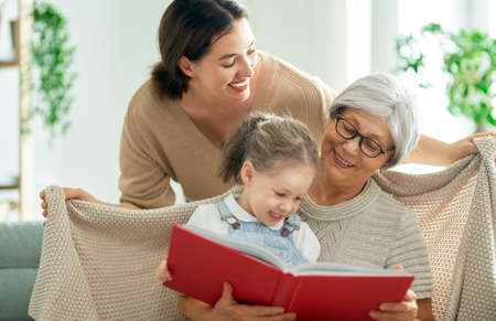 Grandmother reading a book to her granddaughterの写真素材