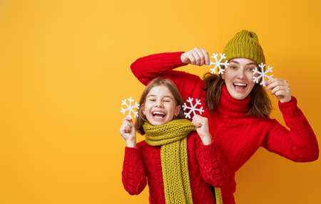 Winter portrait of happy loving family wearing knitted hats, snoods and sweaters. Mother and child...