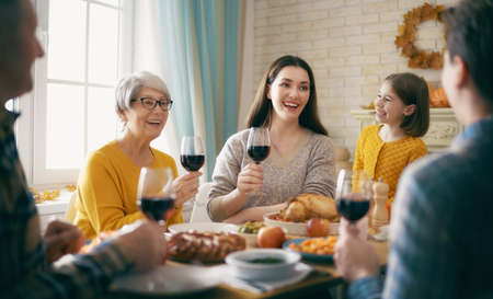 Happy Thanksgiving Day! Autumn feast. Family sitting at the table and celebrating holiday....