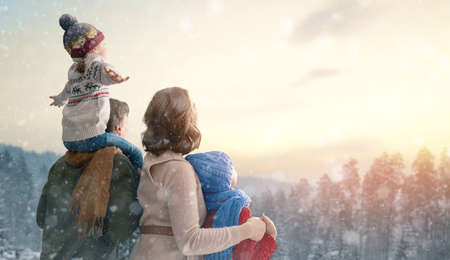 Toward adventure! Happy family are relaxing and enjoying walking. Mother, father and children on snowy winter nature background. Christmas holidays time.                                の写真素材